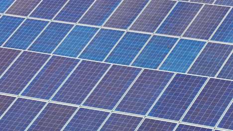 zoom cinematográfico lento en muchos paneles fotovoltaicos en una gran granja solar de energía verde