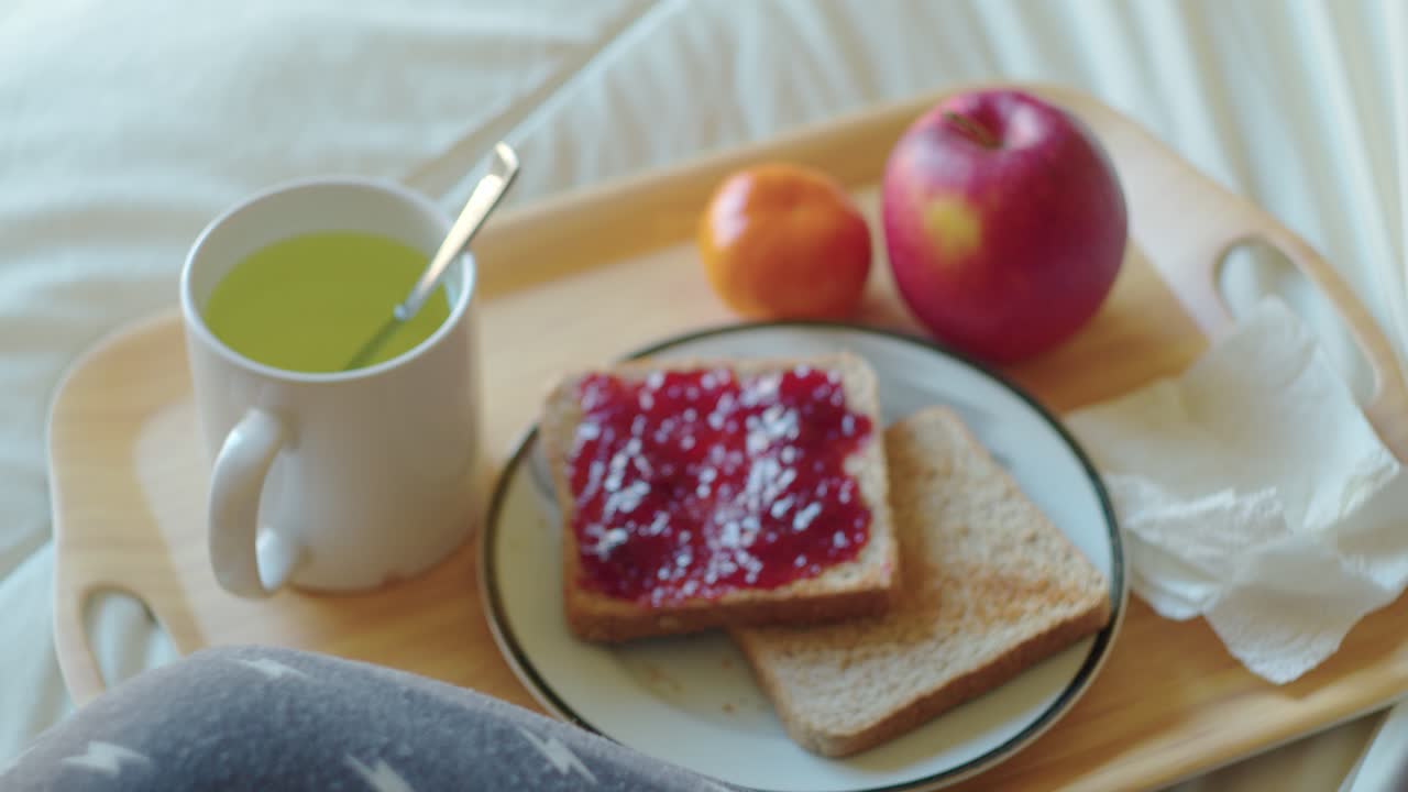 코로나19에서 회복된 환자는 은 날에 온도를 측정하는 동안 침대에 건강한 아침 식사를합니다.