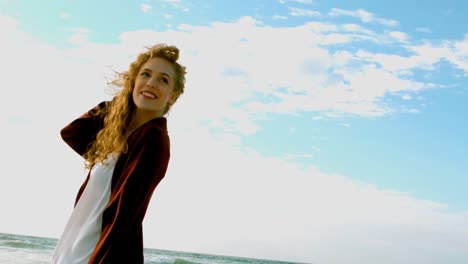 young caucasian woman standing on beach in the sunshine 4k