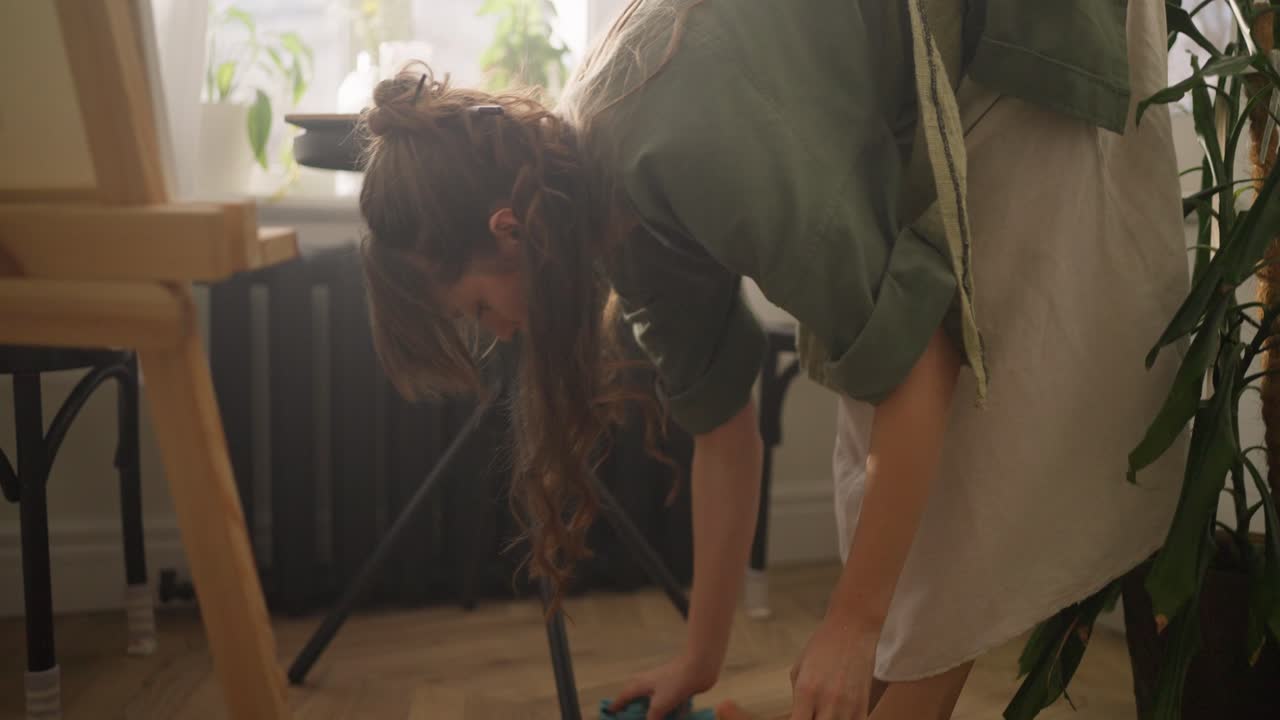 mujer limpiando el estudio de un artista