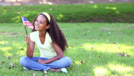 Little-girl-waving-the-american-flag-on-the-grass