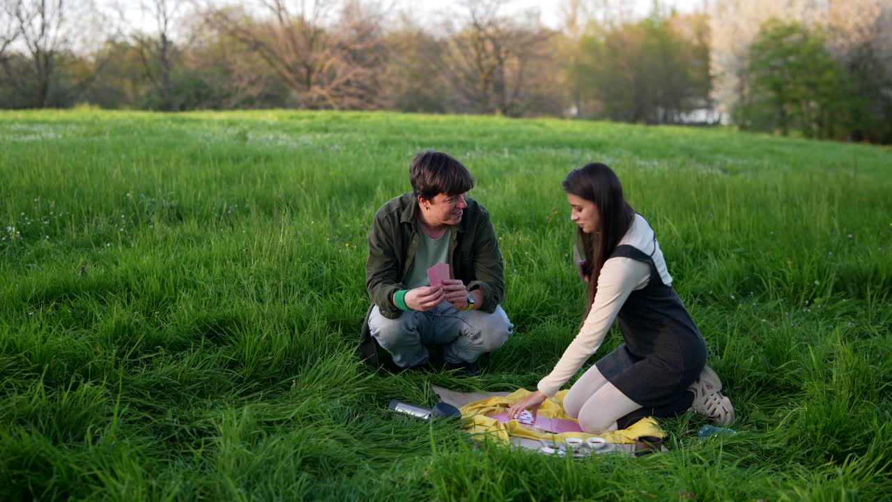 Young Couple Playing Cards in a Field