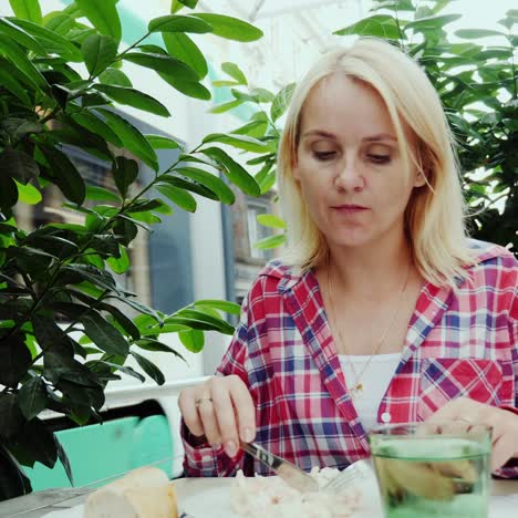 Mujer-Joven-Comiendo-En-Un-Café-En-El-Suelo-De-Verano