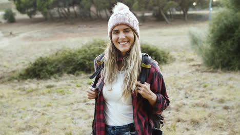 Happy-trekking-girl-wearing-woolen-hat-posing-outdoors