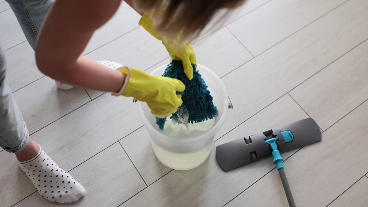Woman cleaning floor with mop and bucket