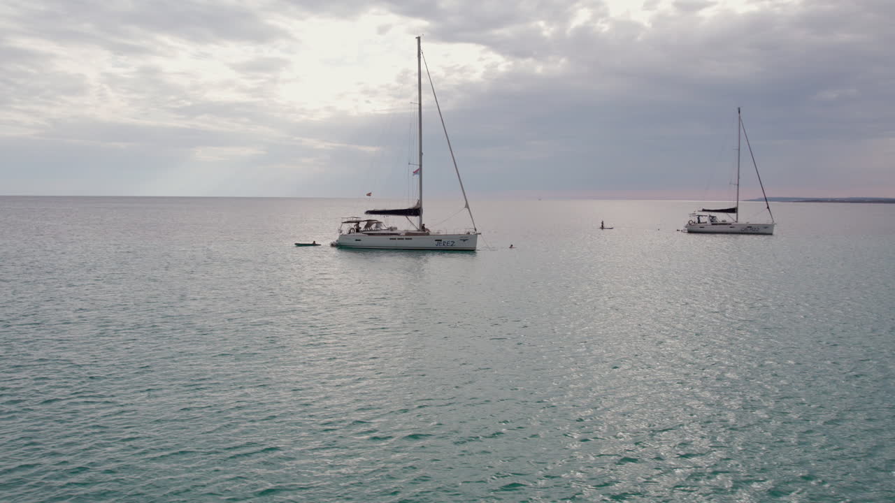 vista aérea de veleros navegando en el mar en la playa del trench en mallorca, españa
