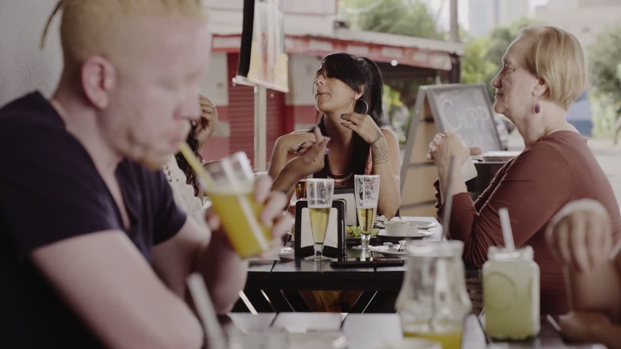 Friends Enjoying Drinks and Conversation at an Outdoor Restaurant