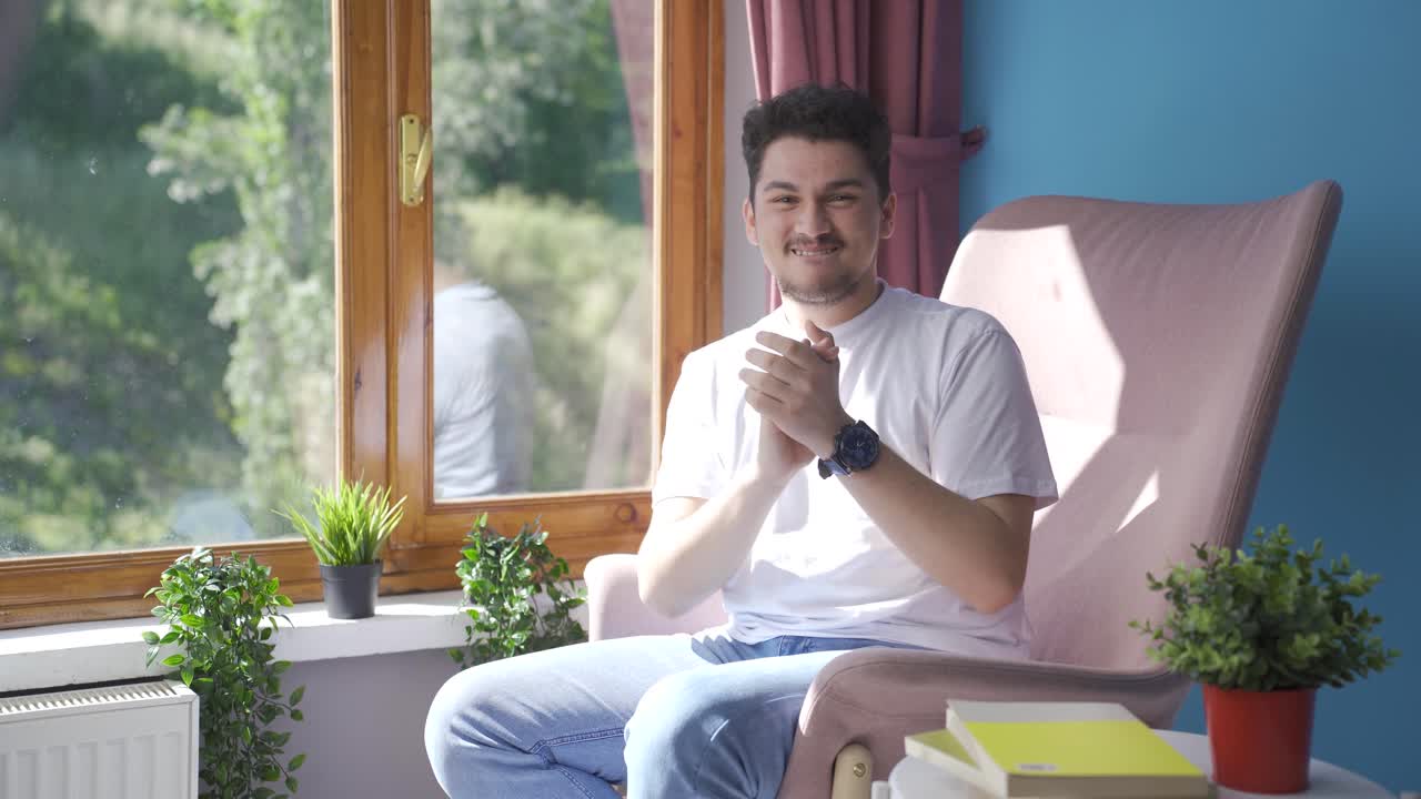 남자가 카메라에 축하 메시지를 보내며 박수를 치고 있습니다.