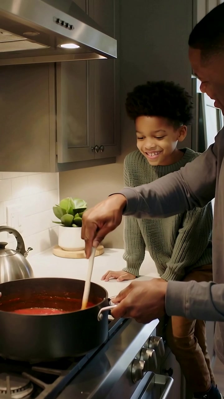 Vertical video: Stirring pa lighting burner making sauce at home with spoon boy watching