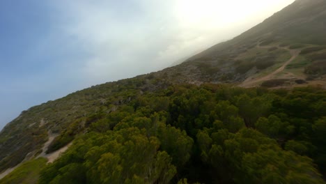 fpv drone flying low across mallorca hills and diving down hills