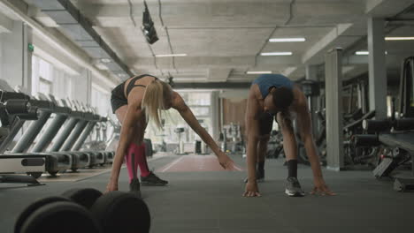 vista frontal de una mujer caucásica y un atlético afroamericano en el gimnasio.