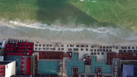 Bird's-Eye-Shot-Of-Beautiful-Blue-Pools-Of-Luxury-Resorts-On-Playa-Del-Carmen-Bay,-Mexico