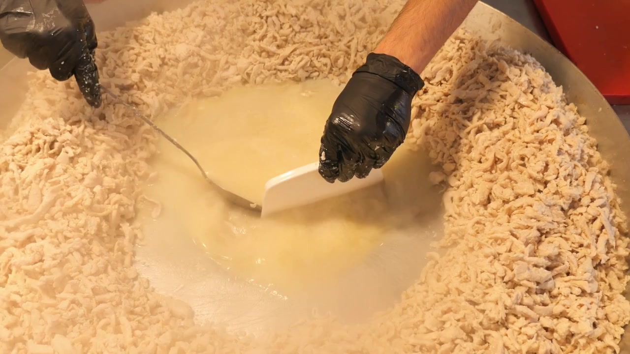 Chef Cooking Shredded Chicken in Large Pan