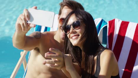 Man-taking-picture-of-himself-with-wife-at-pool