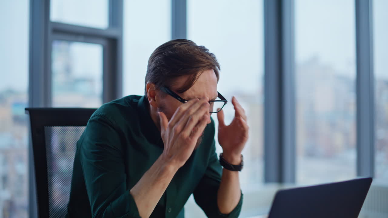 Shocked employee reading dismissal notice at laptop working at office closeup