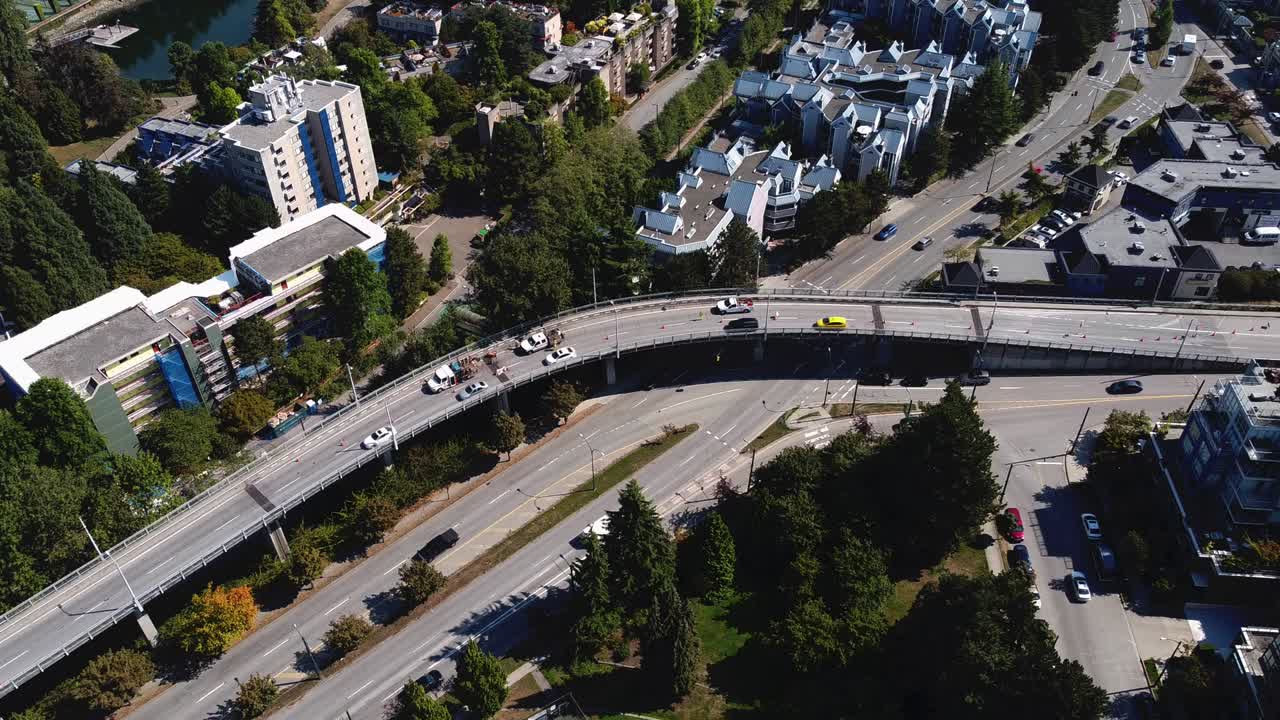 육교 위의 공중 홀드 모든 차선에서 교통 금지 새 보기 저층 아파트 키 큰 나무 흰색 세단 횡단 검은색 suv 노란색 택시 밴 건설 차량 어깨에 주차 1-5