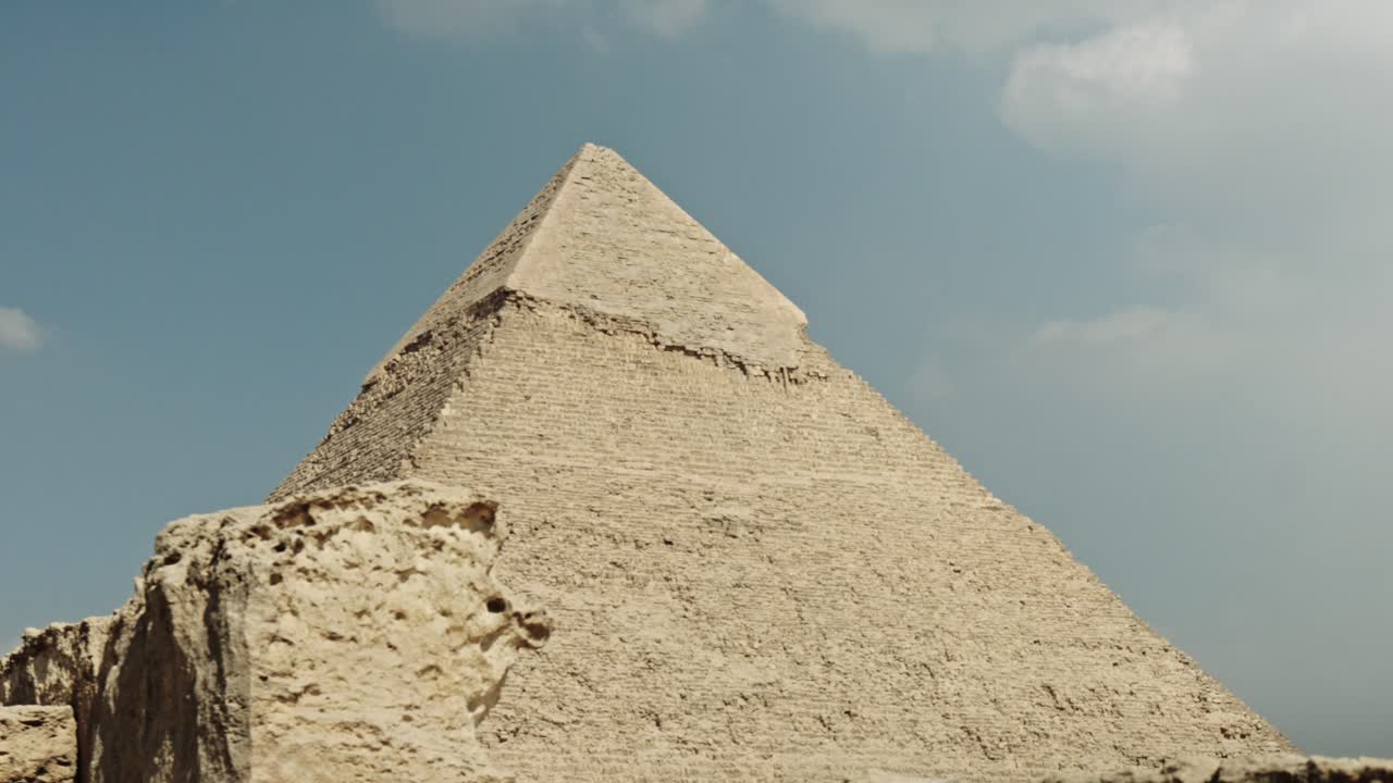 The Pyramid of Khafre, highlighting the pyramid's massive scale and the iconic preserved layer of smooth, white Tura limestone casing stones near its peak