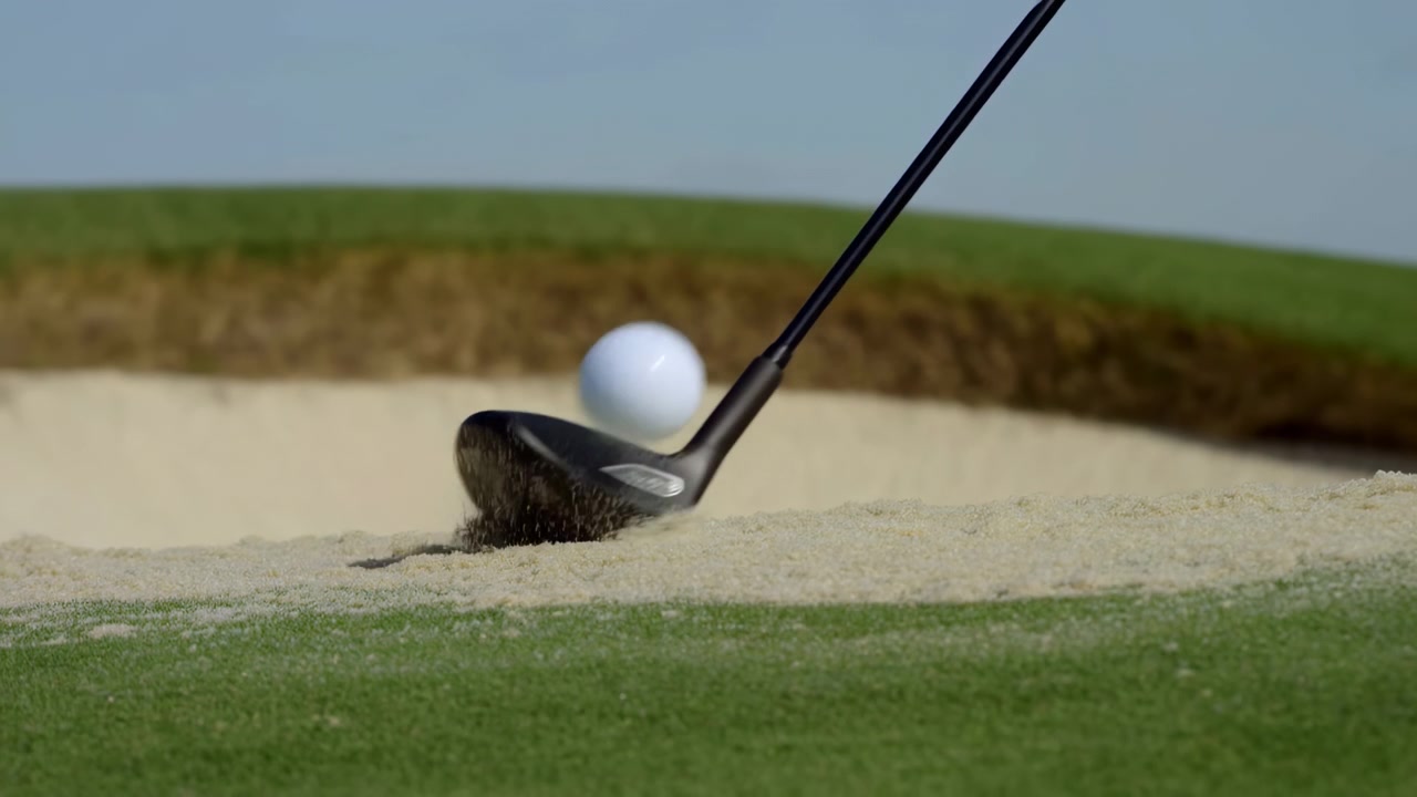 Golf Ball Launched From Bunker, Sand Exploding In Wide Spray As Wedge Strikes, Closeup Of Ball And Clubhead