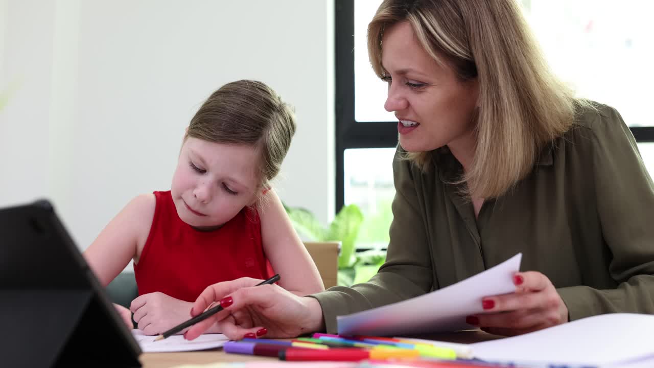 Mother helping child with drawing at home