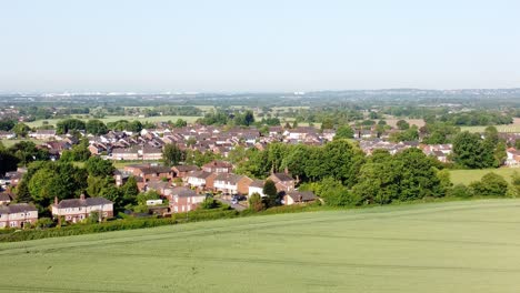 Slow-tilt-up-aerial-shot-of-the-landscape-in-cronton-village-with-view-of-the-fields-and-beautiful-idyllic-residential-houses