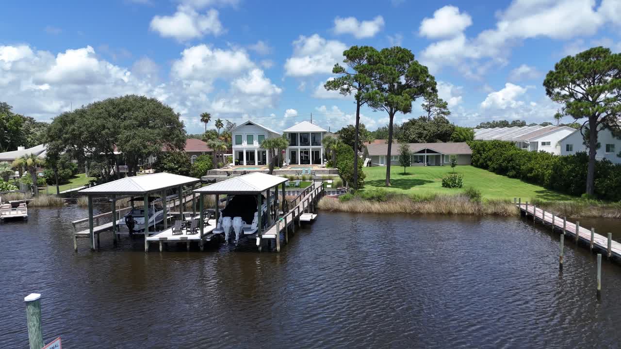 Backwards drone movement from a modern luxury house with swimming pool and backyard in sunny suburb of Panama City Beach, Florida, USA