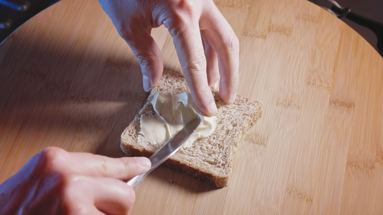 Hands Spread Creamy Cheese Triangle On Whole Wheat Bread