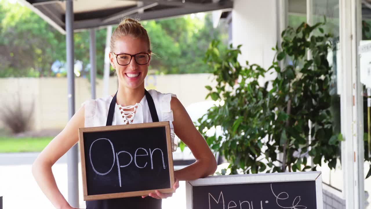 오픈 표지판 을 들고 있는 웨이트리스 의 초상화