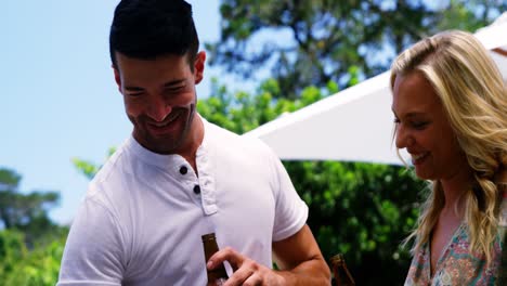 Group-of-friends-having-a-bottle-of-beer-while-preparing-barbeque