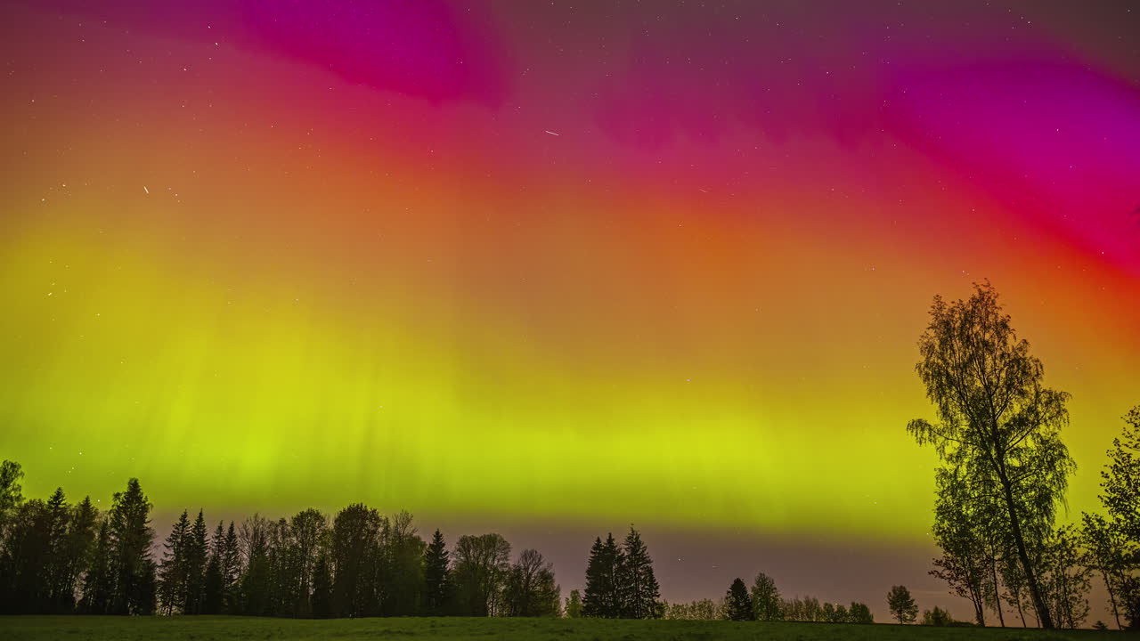 la asombrosamente brillante aurora boreal sobre un paisaje rural - lapso de tiempo
