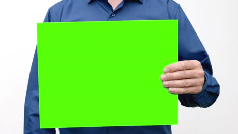 una persona sostiene una pantalla verde delante de él, la eleva y la baja