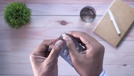 person taking pills from blister pack