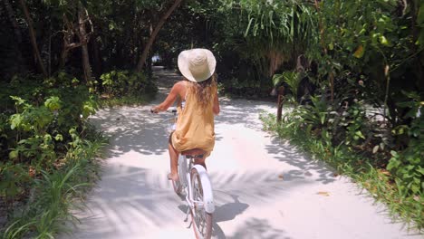 point of view of couple cycling on tropical island around luxury resort in the maldives