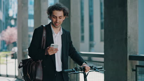 young businessman with electric scooter using smartphone in city