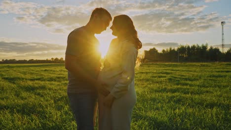 pregnant couple at sunset