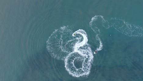 jet skis turn and do donuts in turquoise water of hawaii