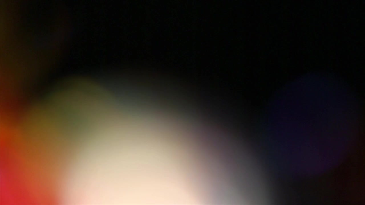 Dynamisk farverigt lyslæk og bokeh-overlay på sort baggrund.