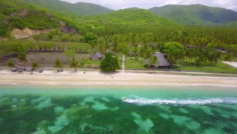 Aerial-of-a-man-riding-a-jet-ski-along-the-clear-green-coast-of-Bali-Indonesia