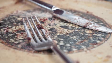 dirty fork and knife on a crumby plate