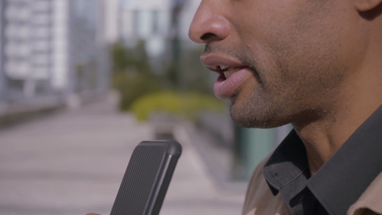 African American man using dictaphone on smartphone
