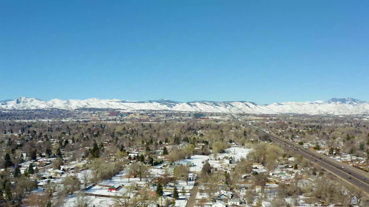 겨울 동안 덴버의 눈 인 산을 내려다보는 도시의 도로의 공중 측면 이동