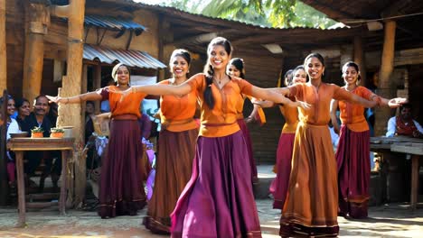young women performing traditional dance in a vibrant village setting