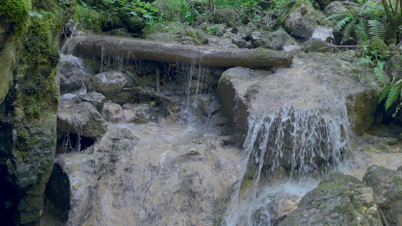 Slow motion pan showing nature waterfall crashing down the green mountains in 4k - Prores footage in super slowmotion