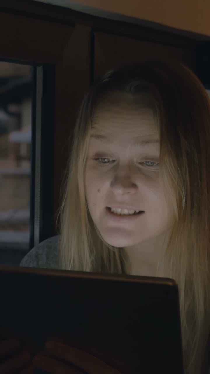 Woman using tablet indoors at night