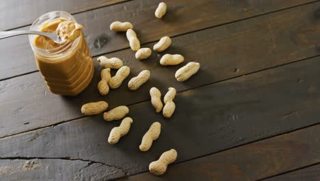 Video-of-close-up-of-peanut-butter-on-wooden-background