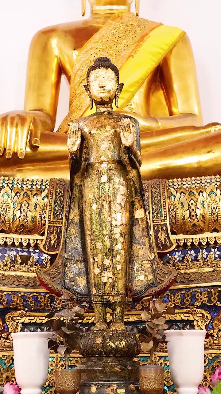 Statue dorate di Buddha con decorazioni floreali
