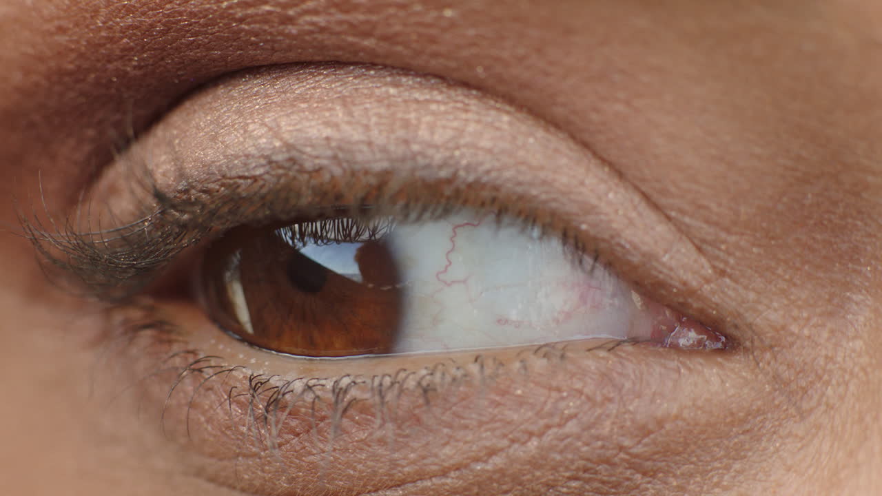 ojo macro de cerca con hermoso iris marrón parpadeando mirando a su alrededor concepto de visión saludable