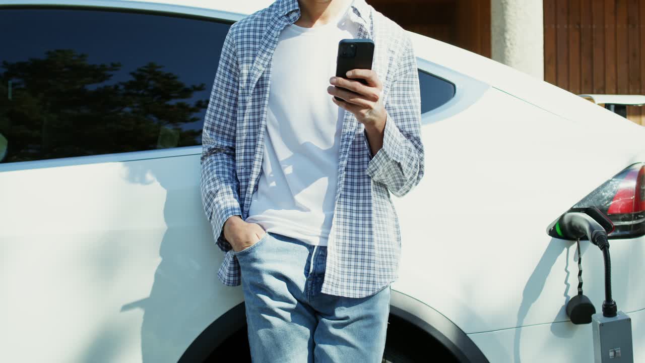 hombre usando un teléfono inteligente para cargar un vehículo eléctrico