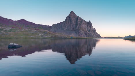 Anayet-peak-and-blue-tent-near-lake-reflection-in-Pyrenees-mountains-during-sunrise-in-Aragon,-Spain