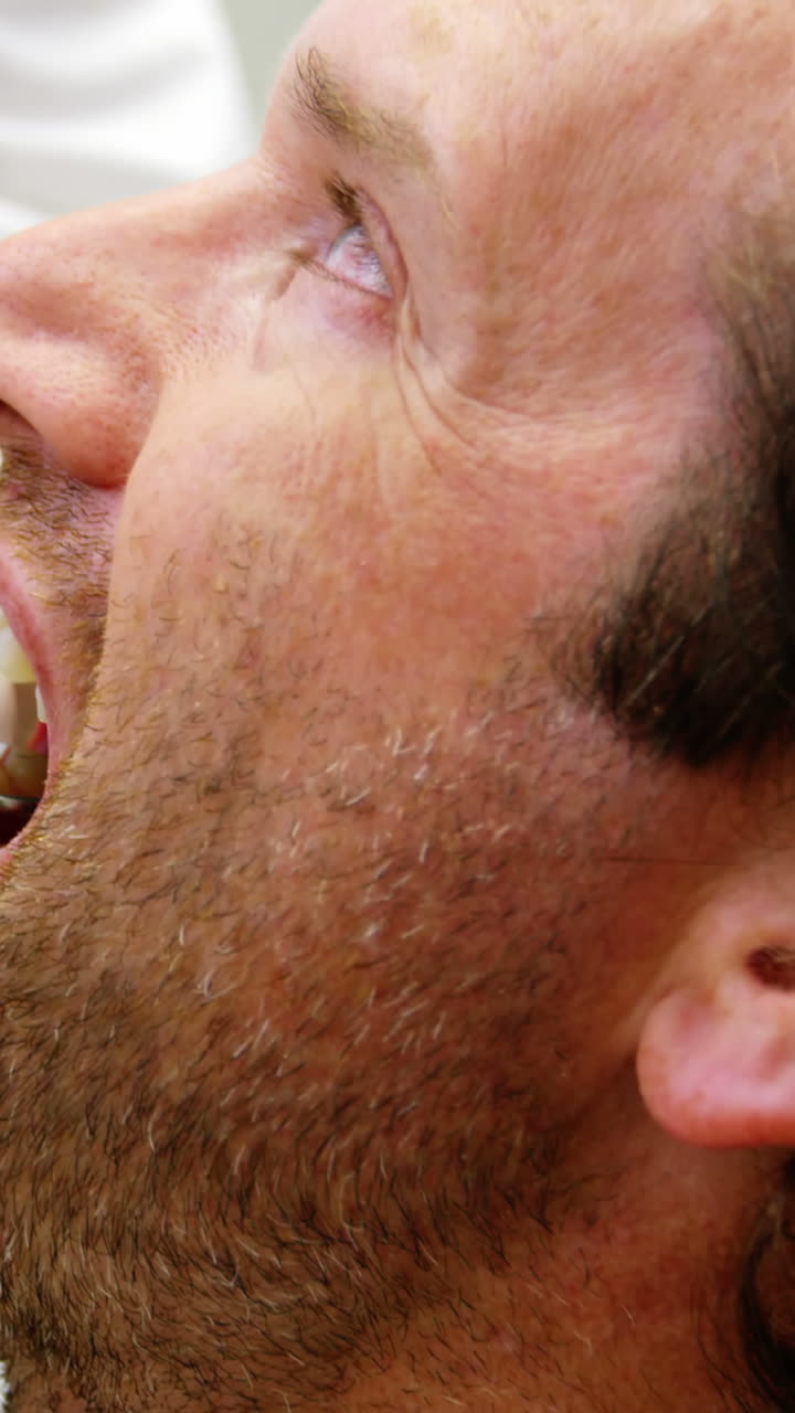 여성 치과 의사가 치과 도구로 남성 환자를 검사합니다.