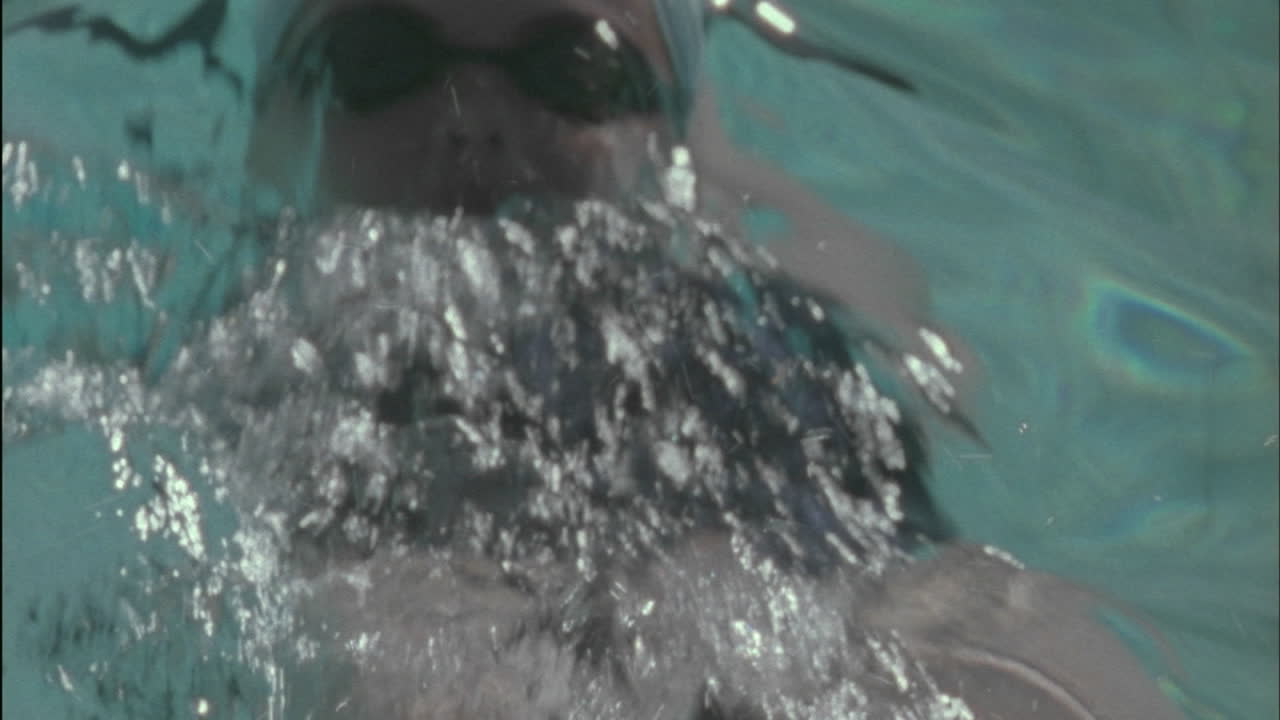 un nadador hace la espalda a través de la piscina